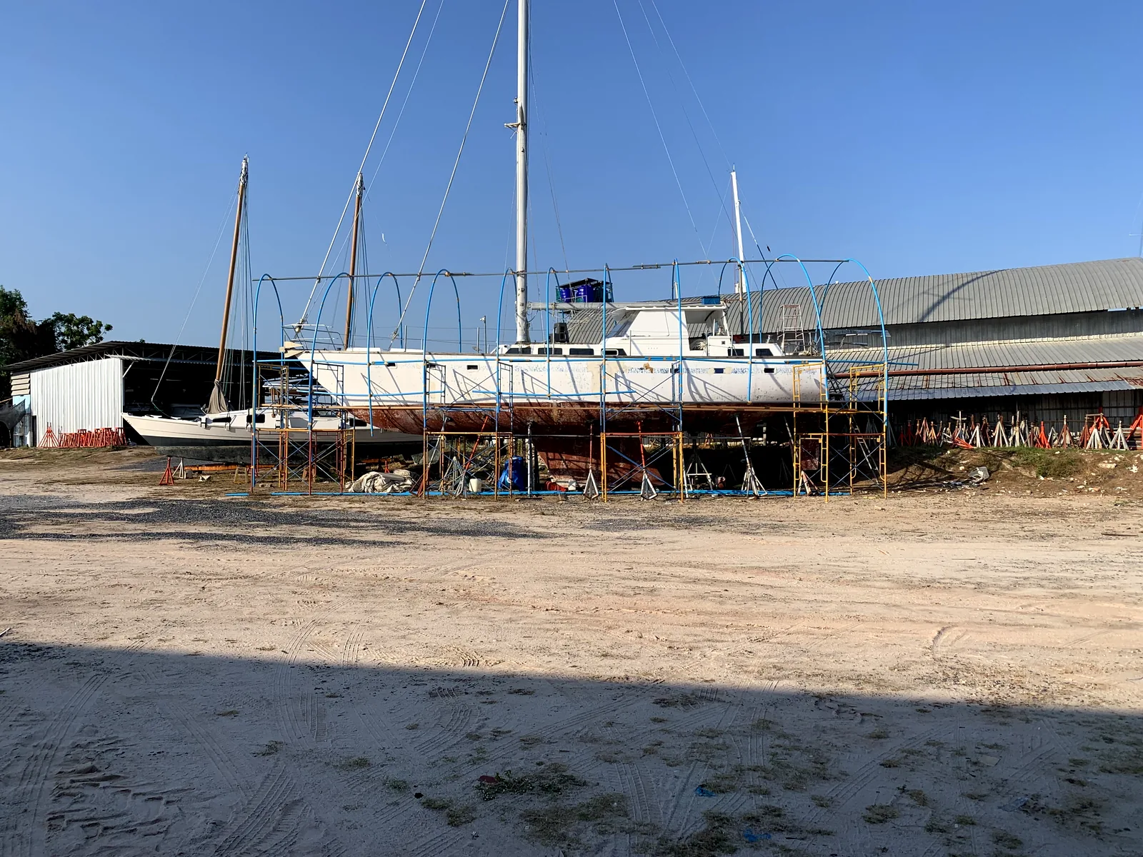 Dragonfly 58 on hardstand at Phuket boatyard — initial condition